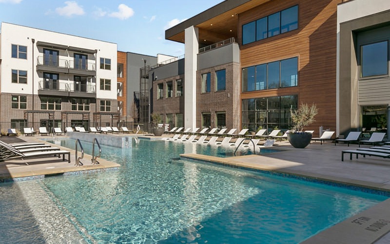 The pool area at our apartments in Fort Worth, featuring beach chairs and a view of the Jameson apartment complex.