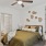 Carpeted one-bedroom with large bed, modern wall decor, ladder desk, desk chair, and en suite bathroom in Downtown Fort Worth